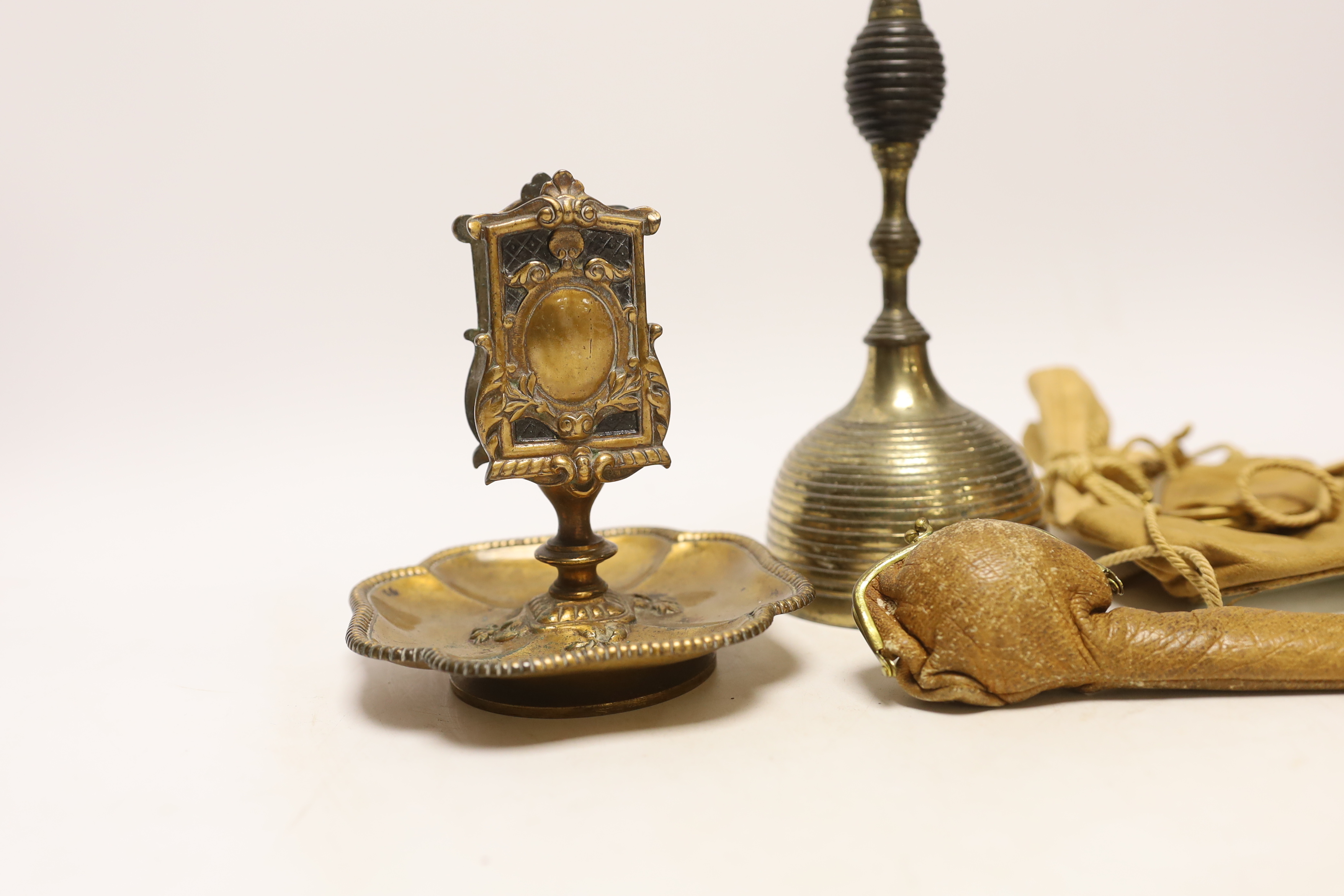 A group of collectables including a bell, a matchbox holder, a pendant, a brooch, etc.